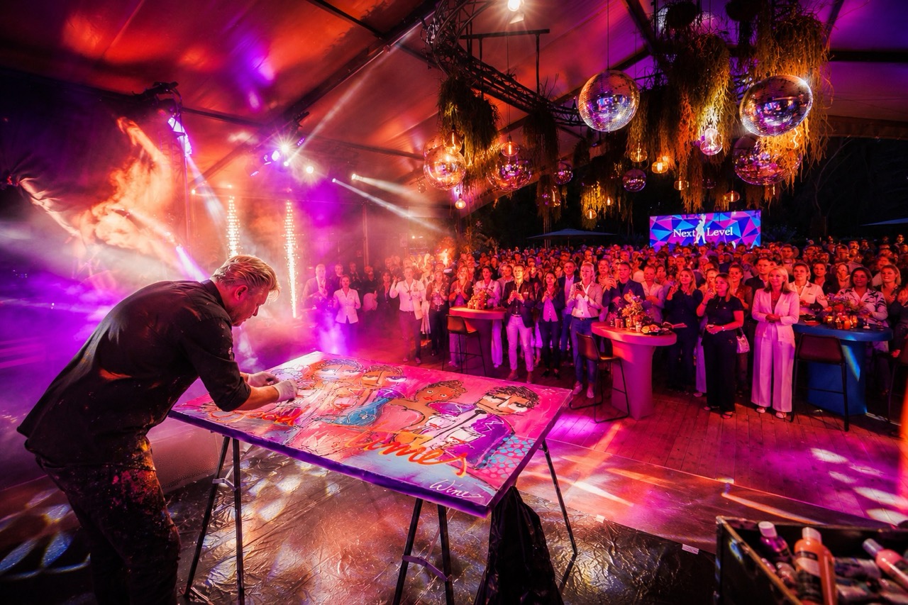 Kunstenaar creëert live een indrukwekkend kunstwerk tijdens een exclusieve ARTmosphere Live Art PREMIUM-show met spectaculaire verlichting, rookeffecten en een enthousiast publiek.